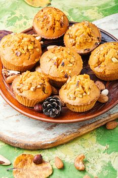 Homemade muffins with nuts on a plate.