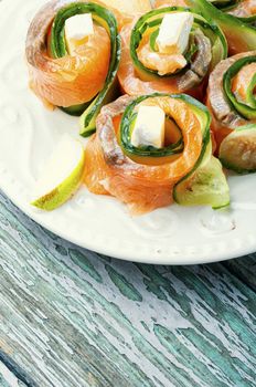 Salmon roll with cheese,cucumber and lime on wooden table