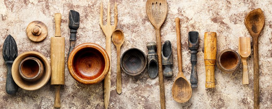 Concept of wooden rustic kitchenware utensils set on old background.Cutlery set