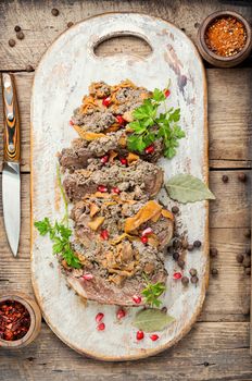 Baked roll from duck breast with stuffing on wooden table