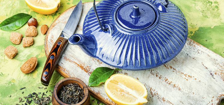 Teapot with tea.Natural ingredients for tea.Porcelain blue teapot.Useful tea with lemon.