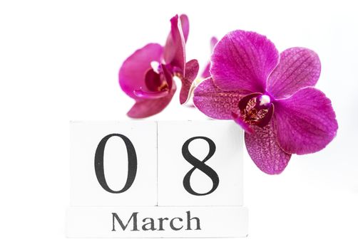 Date white block calendar for International Women's Day, March 8, decorated with orchid flower