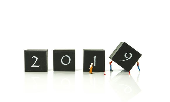 little world miniature figures busy with the turnaround from 2018 to 2019 isolated on white