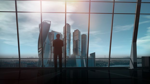 A silhouette of a businessman is standing against an office window with a view of the business center.