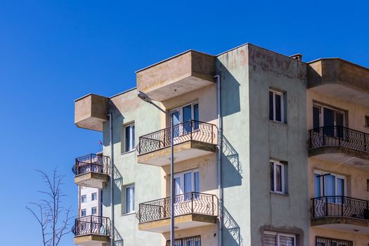 a corner shoot of a very old apartment with brown and white colors - clean blue sky as background. photo has taken at izmir/turkey.