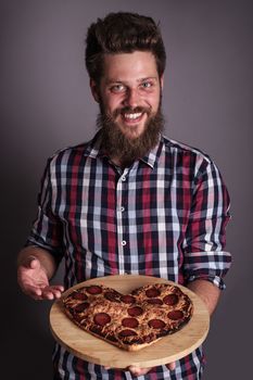 Happy smiling funny man gives burned heart shapes pizza