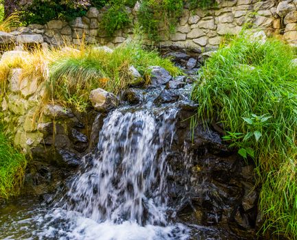 beautiful garden architecture, small waterfall streaming over rocks, nature background