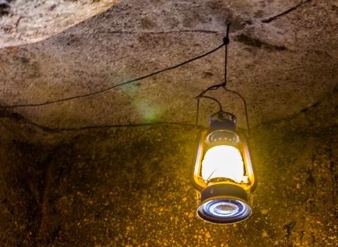 retro lantern hanging on the roof of a cave, Nostalgic mining equipment