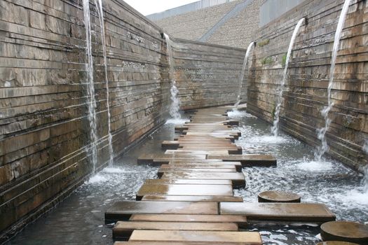 A way to a wall with water outflows over