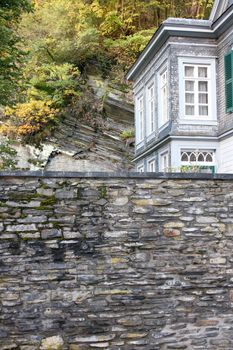 A high stone wall with house corner