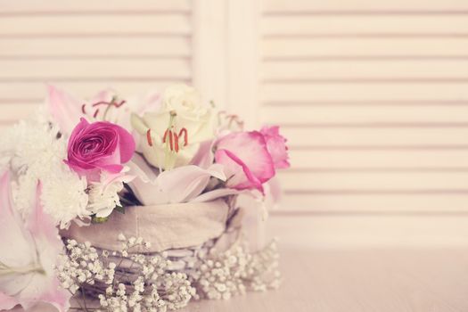 Beautiful bouquet of flowers in basket on wooden background, Valentines day gift concept