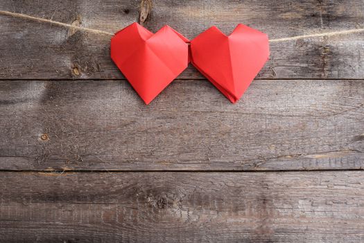 Red origami hearts on rope over wooden background, Valentines day concept, copy space for text