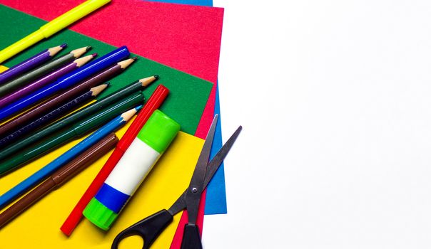 School stationery and supplies on a white background. Creative school background with copy space. Pencils. Felt pen. Glue. Scissors. Colored cardboard. Origami. crafts with your own hands.