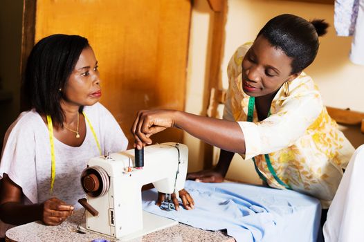professional seamstress helps his student in practice.