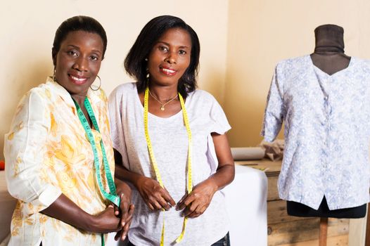Seamstress and student take a picture in their sewing workshop