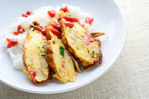 Sliced omelette with soft tofu, crab stick and spring onion with rice on dish