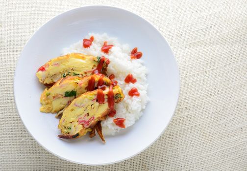 Sliced omelette with soft tofu, crab stick and spring onion with rice on dish