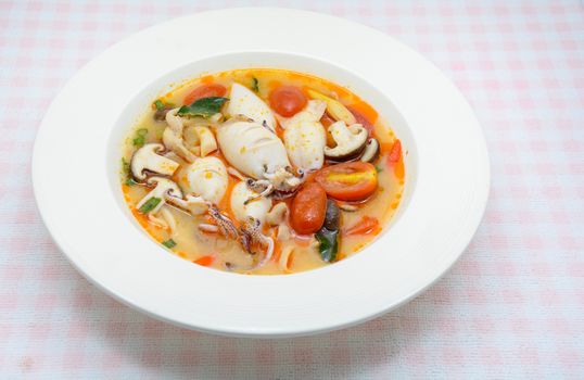 Squids and lemon grass spicy soup with mushrooms, tomatoes and herbs