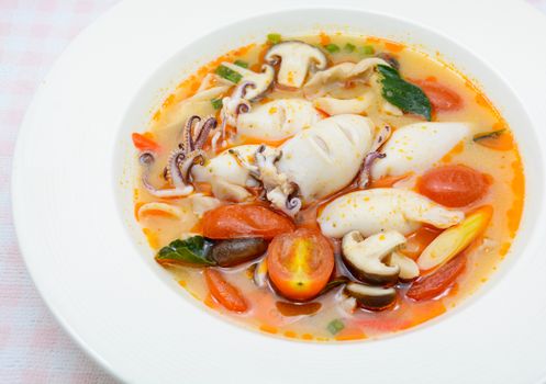 Squids and lemon grass spicy soup with mushrooms, tomatoes and herbs