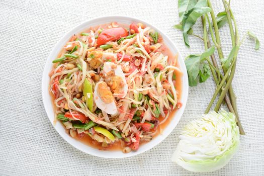 Papaya Salad with Satled Eggs, Pound chilies and garlic then place sliced tomato, eggplant and salted egg. Add fish sauce, lemon, sugar, chopped papaya then mixed all the ingredients together.
