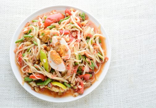 Papaya Salad with Satled Eggs, Pound chilies and garlic then place sliced tomato, eggplant and salted egg. Add fish sauce, lemon, sugar, chopped papaya then mixed all the ingredients together.
