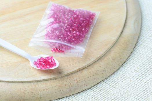 Colorful beads on a wooden surface. Various of shapes and colors to make jewelry
