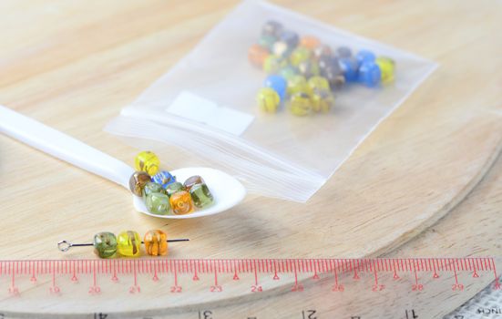 Colorful beads on a wooden surface. Various of shapes and colors to make jewelry
