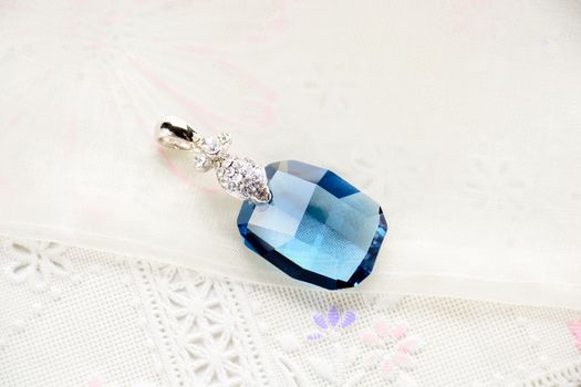 Crystal necklace on white fabric background
