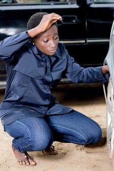 Young female mechanic ready to remove the tire from this car.
