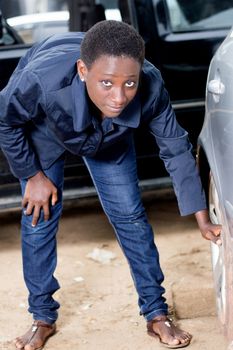 Young female mechanic ready to remove the tire from this car.