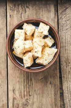 Feta cheese with spice and garlic on old wooden background