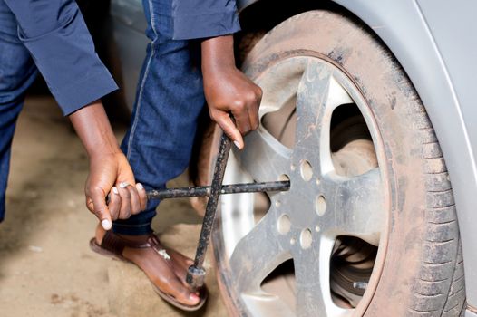 Closeup  of mechanic's arms remove the tire of a car in workshop