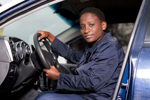 Beautiful young woman sitting at the wheel and looking at the camera.