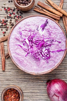 Red cabbage soup on old wooden table.Vegetable soup.Autumn cuisine.