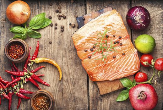 Raw salmon fillet on wooden cutting board