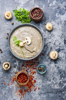 Delicious soup puree with champignons and fresh mushrooms on rustic table