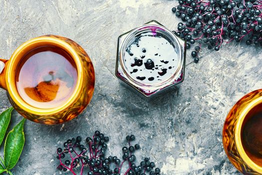 Elderberry jam and fresh berries.Homemade pozzy and a cup of tea