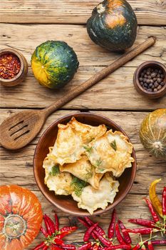 Traditional pumpkin dumplings or vareniki.Fried pumpkin vareniki on wooden background