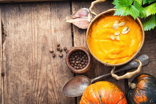 Pumpkin soup on rustic wooden background.Homemade pumpkin soup with spices