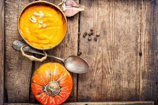 Pumpkin soup on a wooden table.Autumn pumpkin cream soup