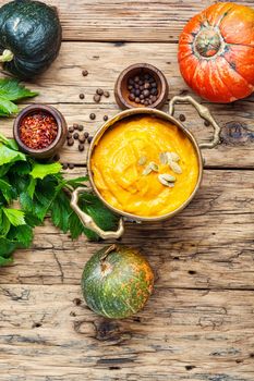 Pumpkin soup on a wooden table.Autumn pumpkin cream soup