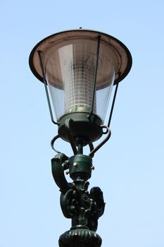 A decorated street lamp, blue sky in the background