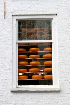 A window with cheeses for sale