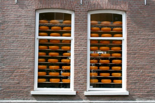 Two windows with cheeses for sale