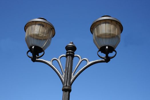 Street light with two lamps, blue sky in the background