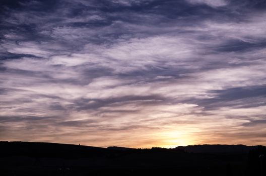 Blue, purple, orange and yellow beautifull sunset behind the hill of Zizur, Navarra, Spain