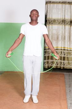 Young man trains by jumping rope in the gym.