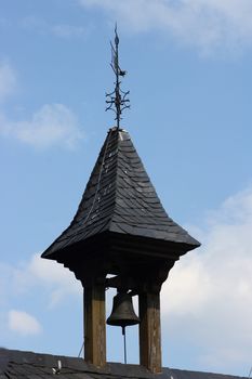 a small bell tower with blue sky in background