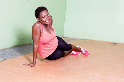 Young woman doing pumps on one arm in the gym.