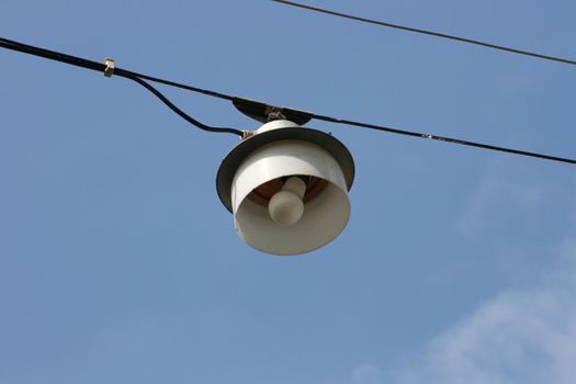 Street lamp on a steel cable suspended above the road,